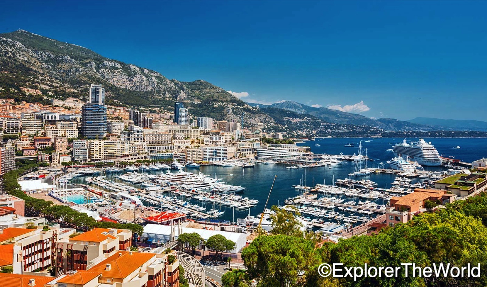 Monaco, Monte Carlo cityscape. Real estate architecture on mountain hill background. Yachts moored at town quay In Sunny Summer Day